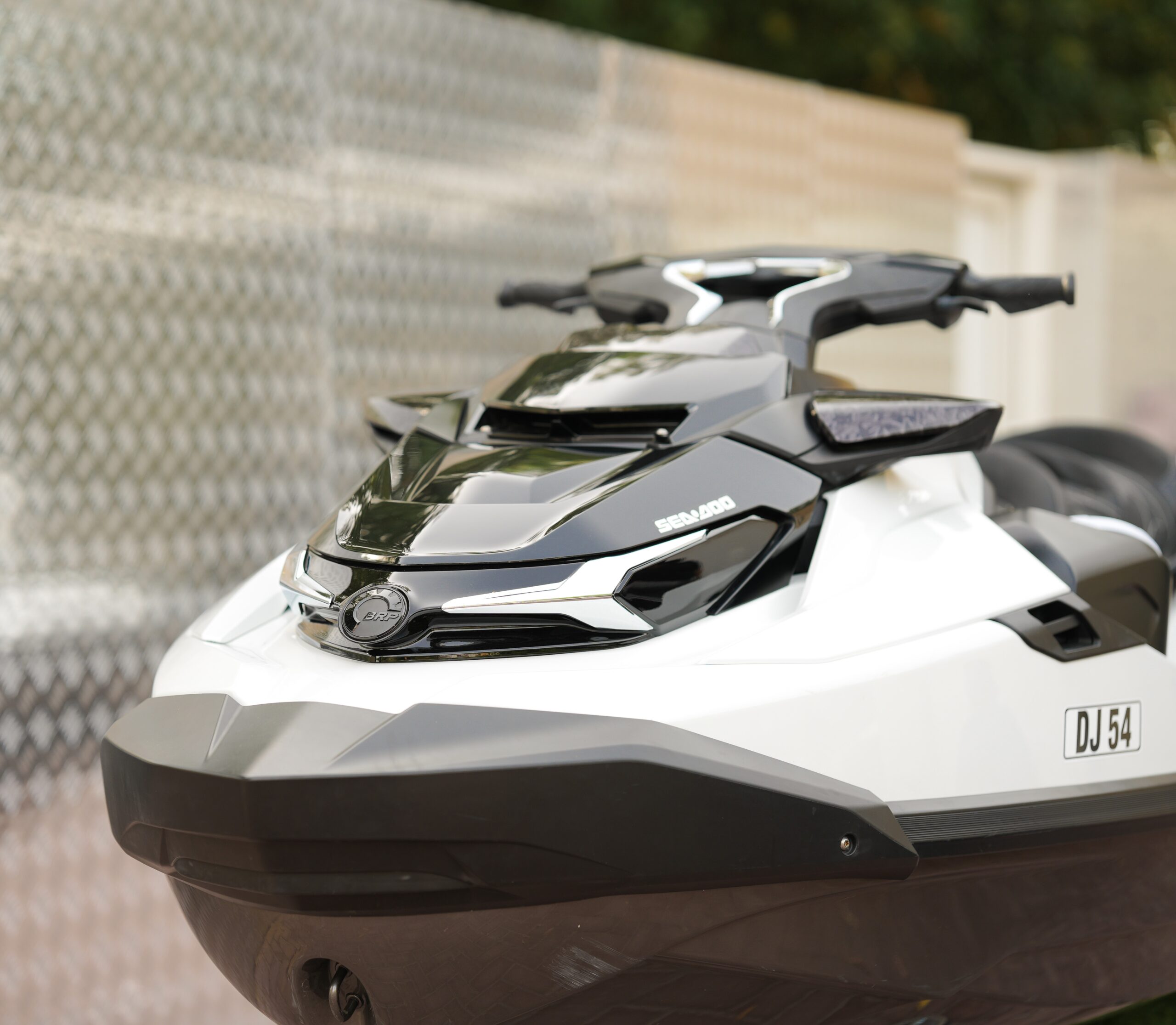 "Sea-Doo personal watercraft jet ski in black and white, displayed outdoors, serviced and maintained by Motocare experts."