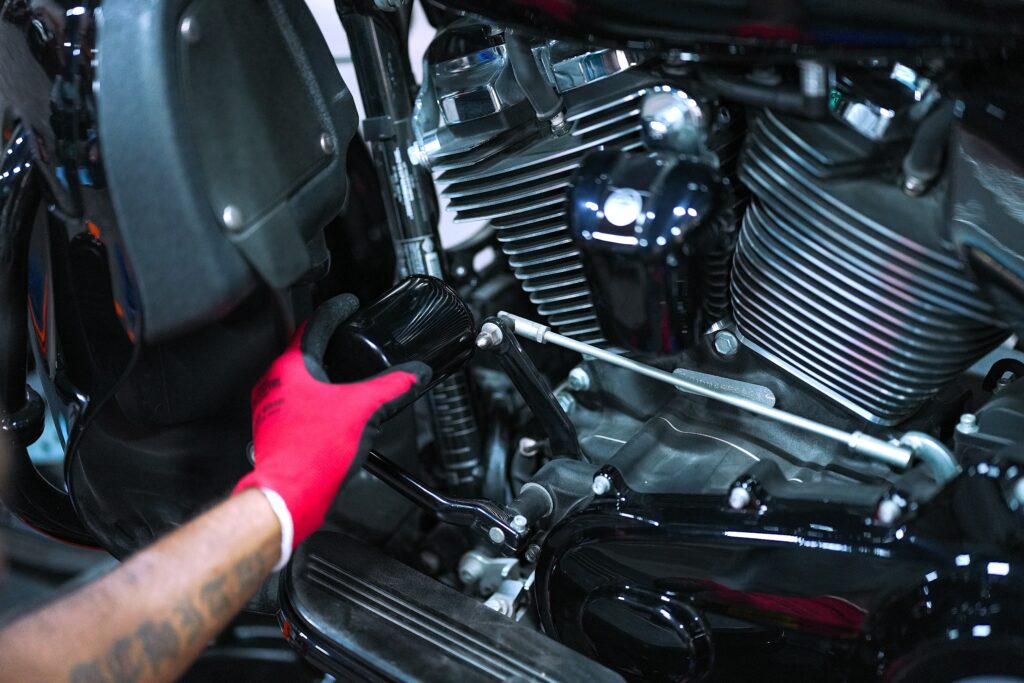 "Mechanic performing motorcycle oil filter replacement with precision – MotoCare UAE professional bike servicing."